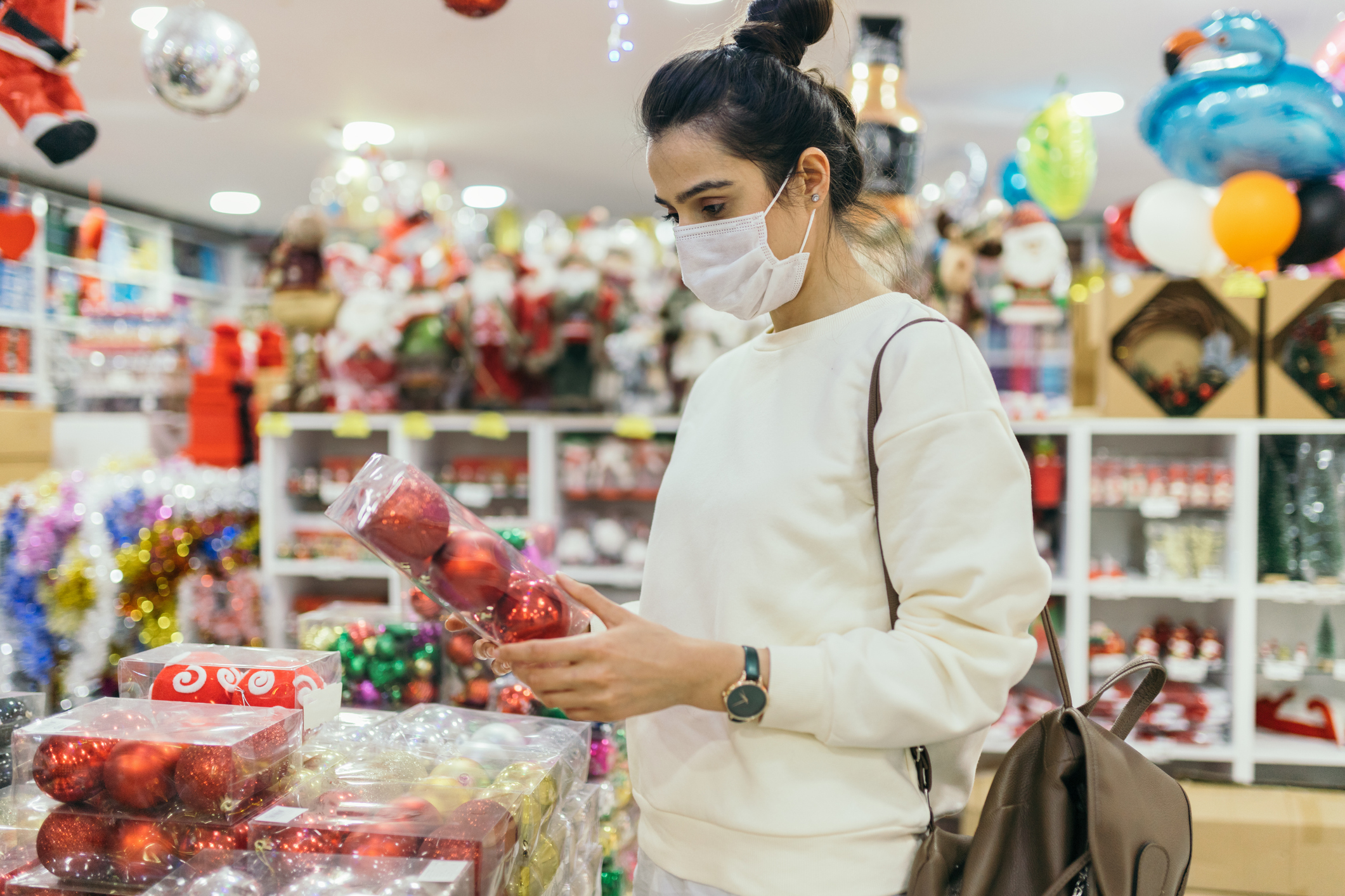 Woman wearing protective face mask and looking at a christmas market stall Woman wearing protective face mask and looking at a christmas market stall